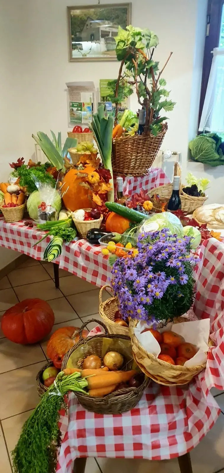 Körbe mit Gemüse, Kürbissen und Blumen schmücken das Kreuzberghaus.