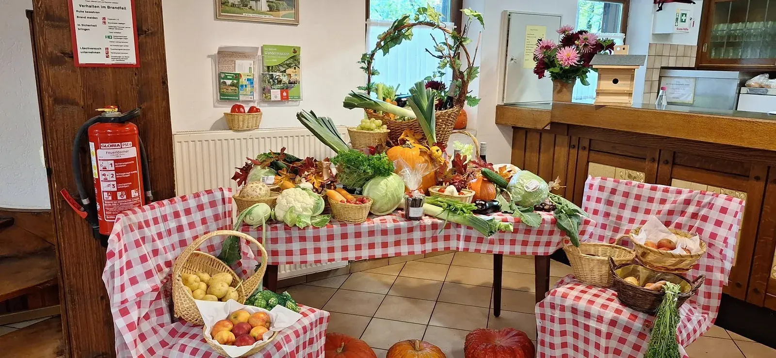 Herbstliche Erntegaben in Körben vor der Theke des Kreuzberghauses.