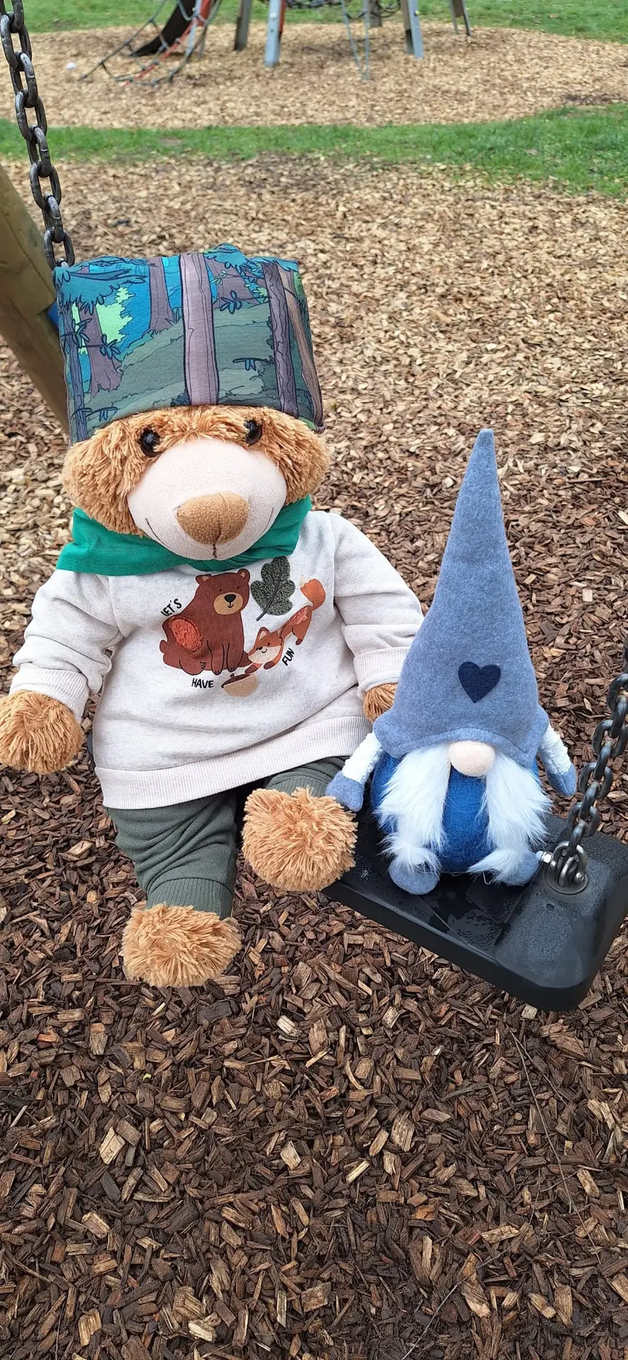 Maskottchen Waldi und eine kleine Wichtelfigur sitzen gemeinsam auf einer Schaukel