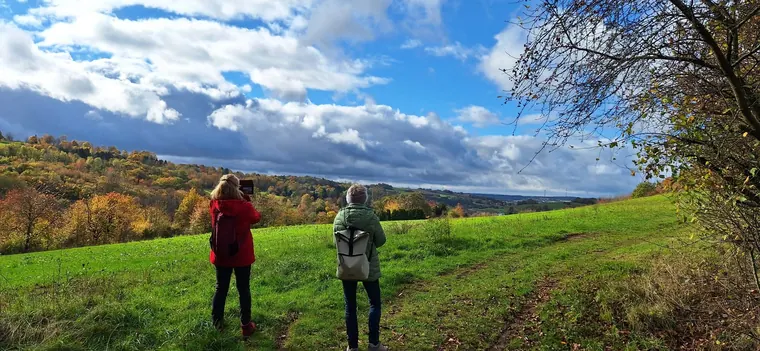 Wanderinnen des Saarwald-Vereins Völklingen blicken über eine grüne Hügellandschaft